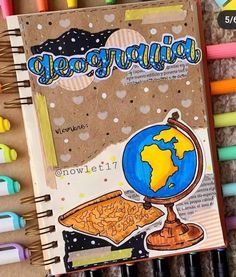 an open notebook with the word geographia written on it next to some markers