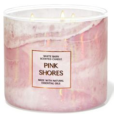 the pink shores candle is in a glass container