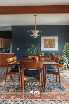 a dining room with blue walls and an area rug that has various chairs around it