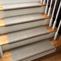 a set of stairs with carpeted treads and wooden handrails in a home