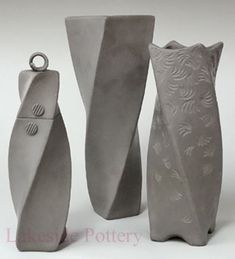 three gray vases sitting next to each other