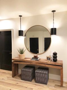 there is a mirror and two stools on the floor in this entryway area