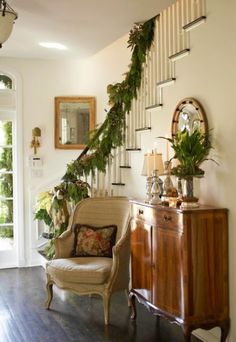 an image of a living room decorated with greenery on the wall and stairs to the second floor