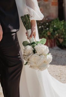 the bride and groom are holding their bouquets