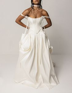 a woman in a white wedding dress posing for the camera with her hands on her hips