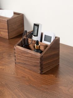 two wooden boxes with electronic devices in them on a wood table next to each other