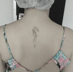 the back of a woman's neck with a small tattoo on her left side