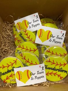 a box filled with yellow softballs covered in personalized magnets that say our team is poppin