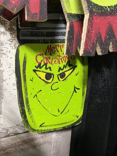 there is a neon green bag hanging on the wall next to a sign that says merry christmas