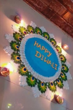 happy diwali written on the wall with lit candles around it and decorated with flowers