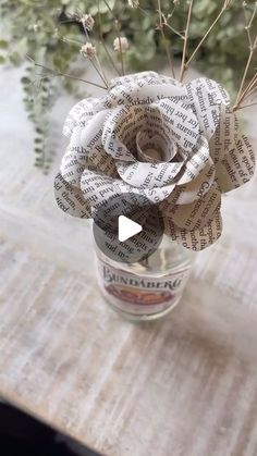 a vase filled with paper flowers sitting on top of a table