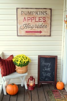 the porch is decorated with pumpkins, apples and hay bales for fall decor