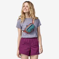 a woman wearing purple shorts and a grey t - shirt