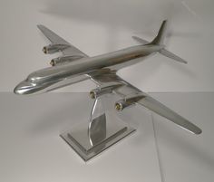 a model airplane is on display in a glass case with metal stand legs and feet