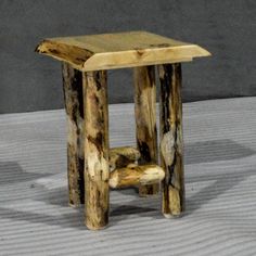 a small wooden stool sitting on top of a white floor next to a gray wall