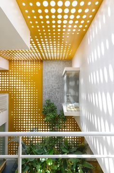 the interior of a modern house with yellow walls and white perfored ceilinging