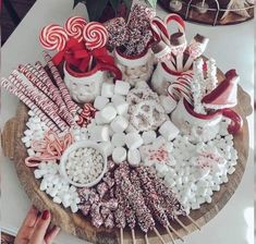 a wooden platter filled with lots of candies and lollipop canes