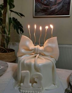 a birthday cake with candles in the shape of a bow