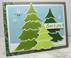 a handmade christmas card with green trees and snowflakes on the bottom corner