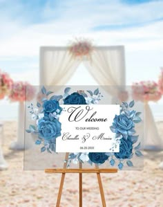 an easel with a sign on it that says welcome to our wedding and blue flowers