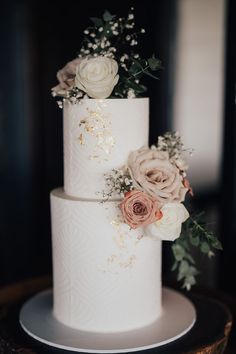 a white wedding cake with flowers on top