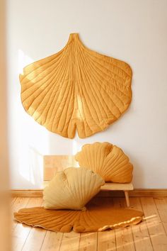 two scallop shells are on the floor in front of a white wall and wooden bench