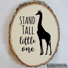 a wood slice with a giraffe on it that says stand tall little one