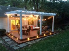 a deck with lights on it and patio furniture