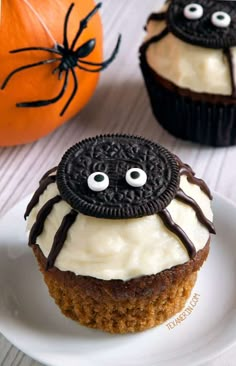 two cupcakes decorated with oreo cookies and white frosting on a plate