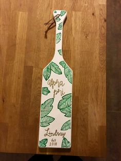 a wooden spatula with the words utopia pii and leaves on it sitting on a table