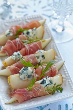 appetizers with prosciutto, pears and blue cheese on a white platter