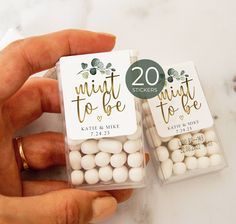 two small white candy bags with gold foil lettering on the front and one is filled with wedding favors