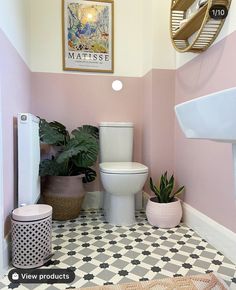 a bathroom with pink walls and black and white flooring, potted plants on the side