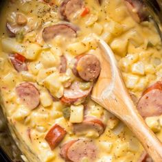 sausage and macaroni casserole in a crock pot with a wooden spoon