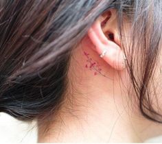 the back of a woman's ear with pink ink