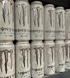 several cans of monster energy drink stacked on top of each other in a store shelf