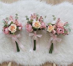 three bridal bouquets with pink and white flowers on a furnishing area