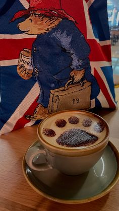 a cup of cappuccino on a saucer with the british flag in the background