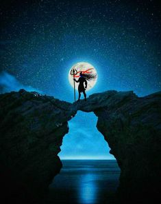 a person standing on top of a cliff under a full moon