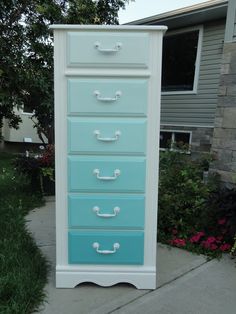 a blue and white dresser sitting on top of a sidewalk