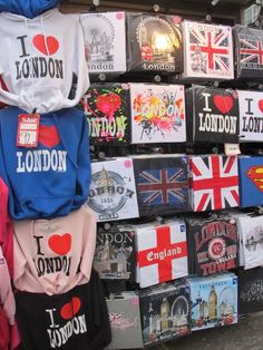 many different colored shirts are on display in front of a wall with the words i love london