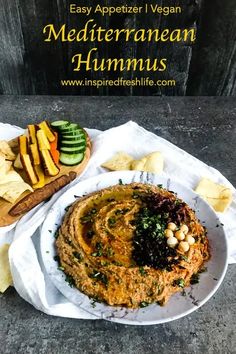 a plate with hummus and chips on it next to a wooden board that says easy appetizer vegan mediterranean hummus