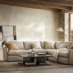 a living room with a sectional couch and coffee table in front of a large window