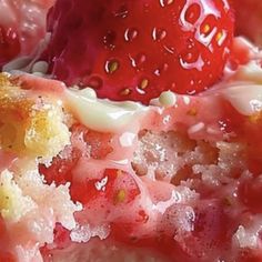 a close up view of a piece of cake with strawberries on top and frosting