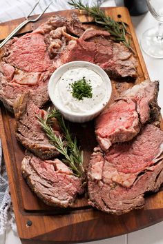 a wooden cutting board topped with steak and ranch dressing