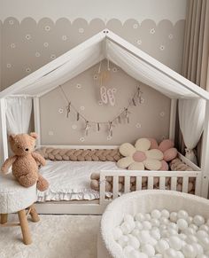 a teddy bear is sitting in the corner of a room with a crib and bed