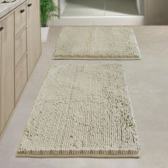 two rugs on the floor in a bathroom