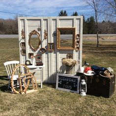 an outhouse is set up in the grass with two chairs and a table on it