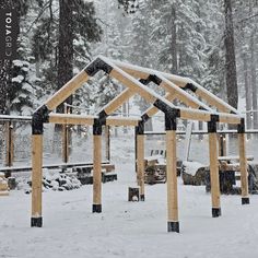 a wooden structure sitting in the middle of a snow covered forest