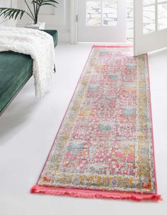 an area rug with bright colors and fringes on the floor in front of a white door